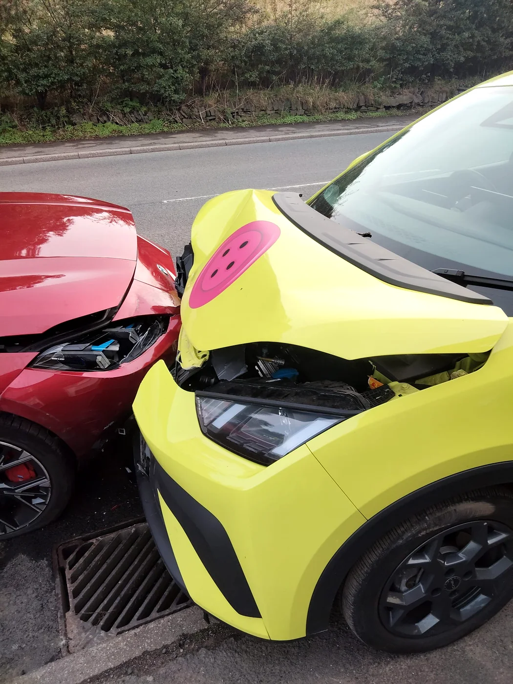 Collision damage to a yellow car beside a red car