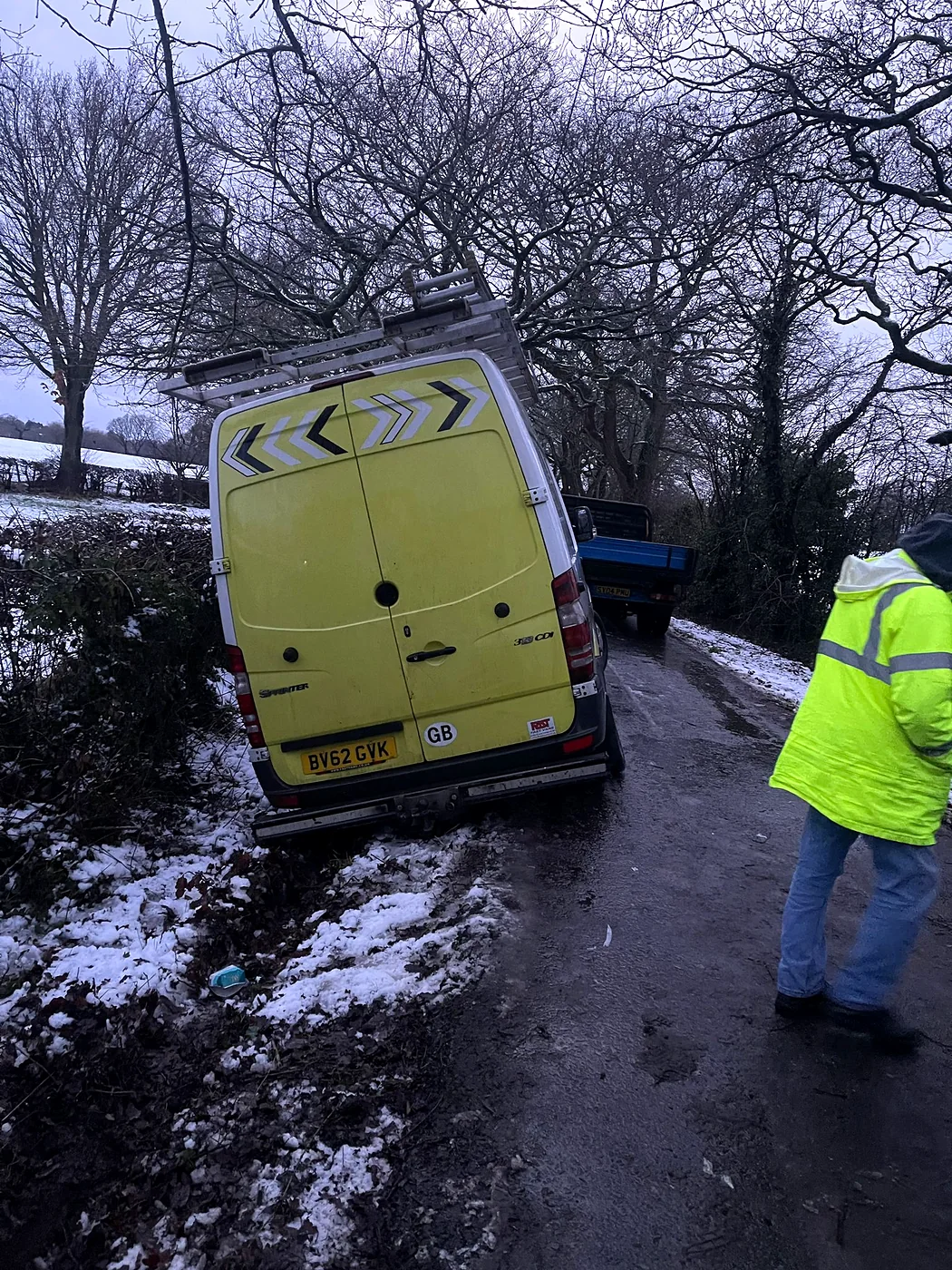 Mercedes Sprinter van in a ditch beside a snowy lane
