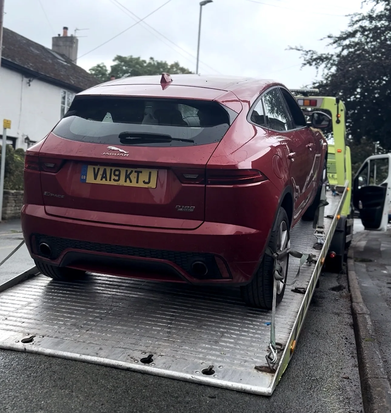 Red SUV secured on a recovery bed