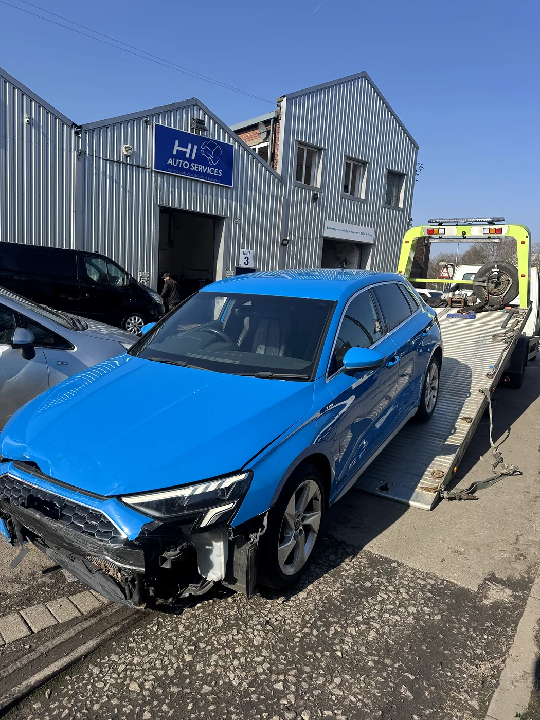 Damaged blue Audi positioned at the recovery bed