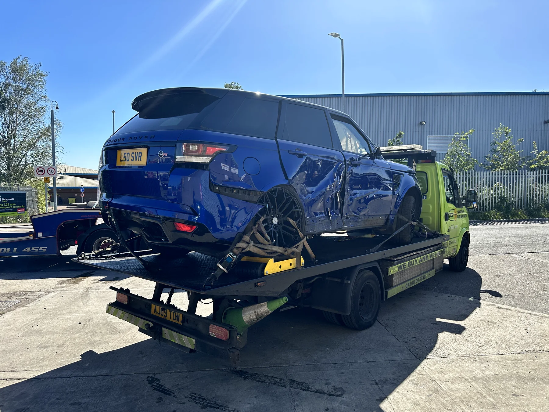 Side damage to a blue SUV loaded for recovery
