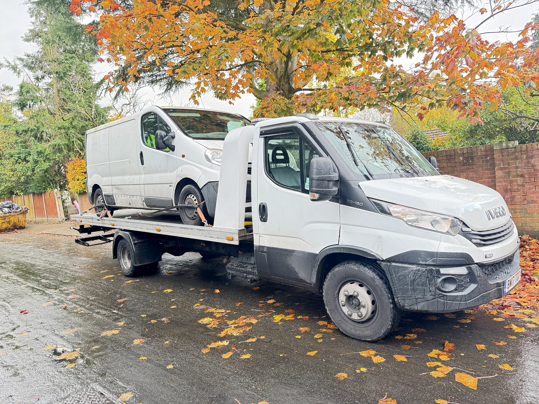 White Iveco transporting a white van on a residential road